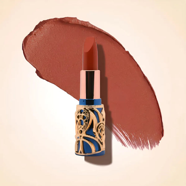 Swiss Miss Bling Lipstick in shade Bronze Affair B-113 featuring ornate blue and gold filigree bullet tube casing with a warm terracotta bronze brown lipstick swatch.