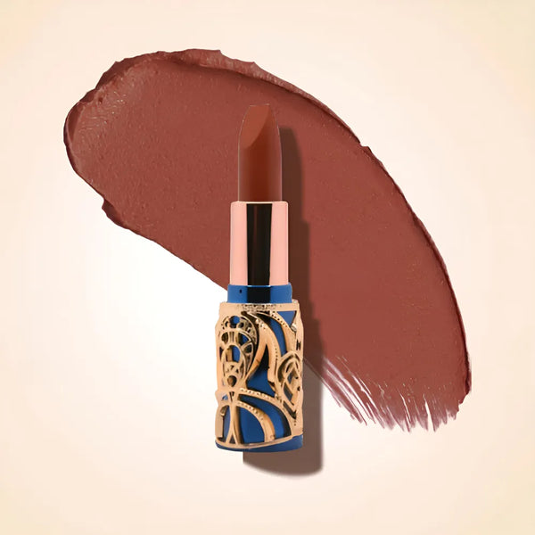 Swiss Miss Bling Lipstick in shade Show Stopper B-114 featuring ornate blue and gold filigree bullet tube casing with a deep chestnut warm brown lipstick swatch.