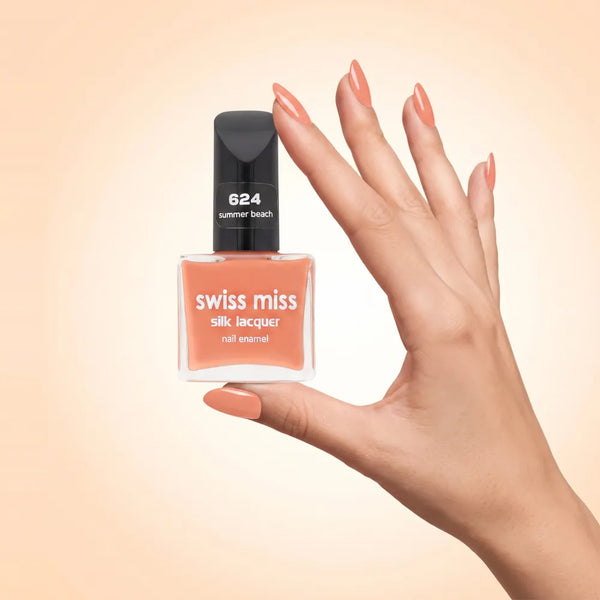 Swiss Miss Silk Lacquer Nail Enamel in shade Summer Beach 624 held by hand showing clear glass square bottle with warm peach nude orange polish and matching manicured nails.
