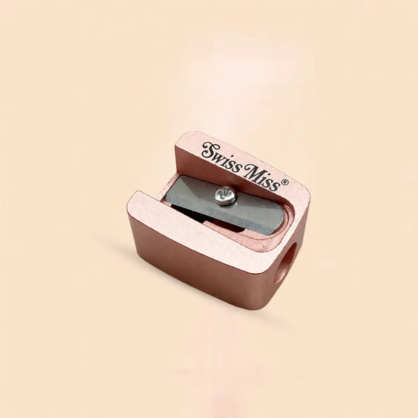 Swiss Miss rose gold metallic cosmetic pencil sharpener with single blade for lip and eye pencils.