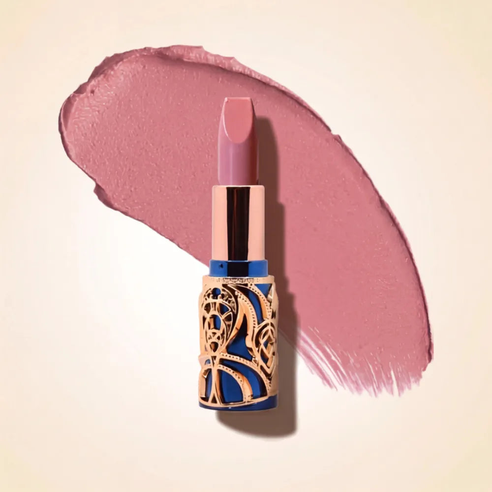 Swiss Miss Bling Lipstick in shade Mocha Mousse B-102 featuring ornate blue and gold filigree bullet tube casing with a cool dusty mauve pink lipstick swatch.