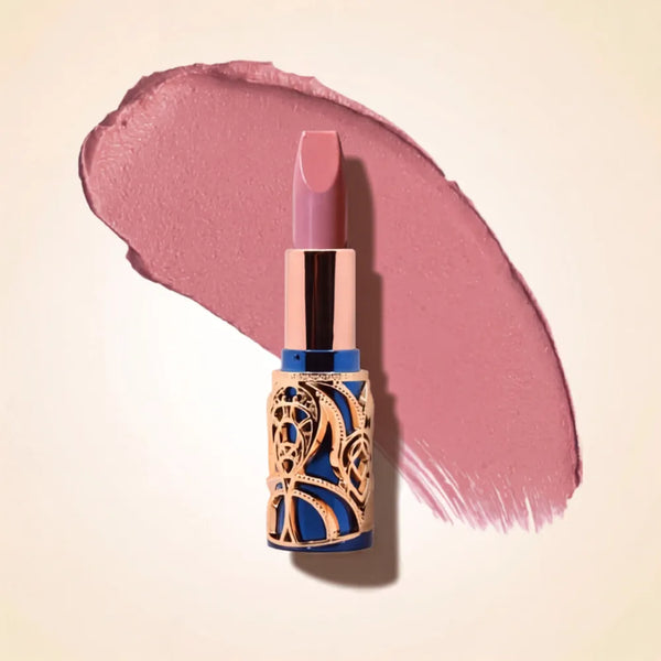Swiss Miss Bling Lipstick in shade Mocha Mousse B-102 featuring ornate blue and gold filigree bullet tube casing with a cool dusty mauve pink lipstick swatch.