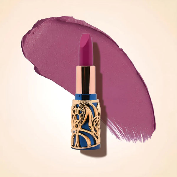 Swiss Miss Bling Lipstick in shade Pink Duchess B-111 featuring ornate blue and gold filigree bullet tube casing with a cool dusty plum purple lipstick swatch.