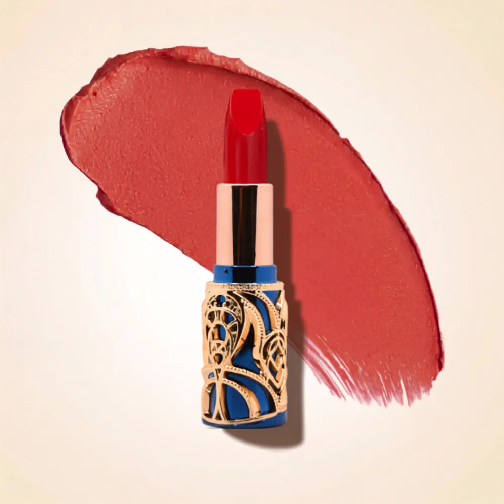 Swiss Miss Bling Lipstick in shade Red Diva B-116 featuring ornate blue and gold filigree bullet tube casing with a vibrant warm scarlet red lipstick swatch.