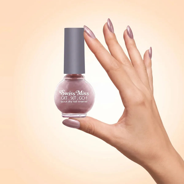 Swiss Miss Get Set Go Quick Dry Nail Enamel in shade Copper Kettle 823 held by hand showing round glass bottle with shimmering metallic dusty rose copper polish and matching manicured nails.