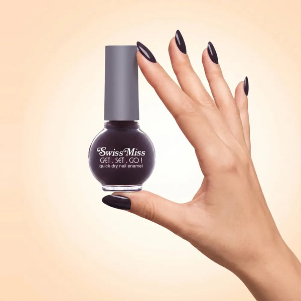 Swiss Miss Get Set Go Quick Dry Nail Enamel in shade Deep Maroon 226 held by hand showing round glass bottle with ultra dark deep maroon plum polish and matching manicured nails.
