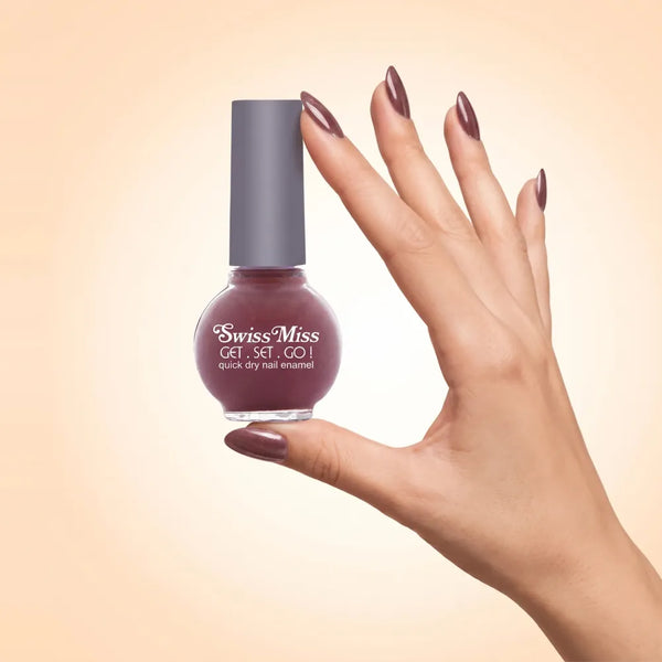Swiss Miss Get Set Go Quick Dry Nail Enamel in shade Flint (Vista) 242 held by hand showing round glass bottle with shimmering metallic dusty rosy mauve brown polish and matching manicured nails.