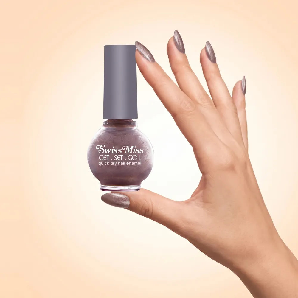 Swiss Miss Get Set Go Quick Dry Nail Enamel in shade Maple Sugar 831 held by hand showing round glass bottle with shimmering metallic dusty taupe brown polish and matching manicured nails.
