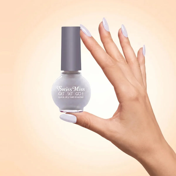 Swiss Miss Get Set Go Quick Dry Nail Enamel in shade Milky White 292 held by hand showing round glass bottle with smooth soft milky white polish and matching manicured nails.