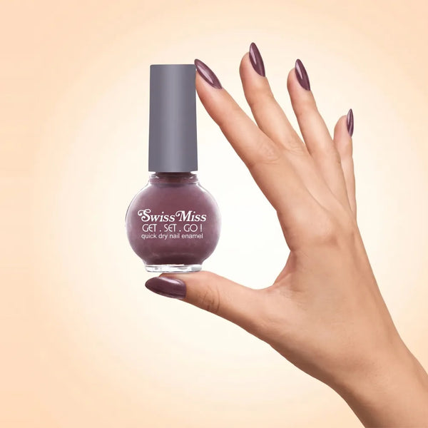 Swiss Miss Get Set Go Quick Dry Nail Enamel in shade Moonless Nite 234 held by hand showing round glass bottle with shimmering metallic smoky plum brown polish and matching manicured nails.