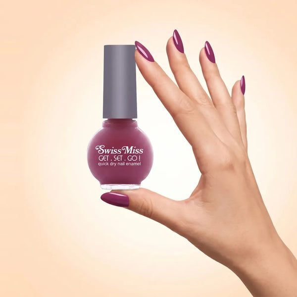 Swiss Miss Get Set Go Quick Dry Nail Enamel NP - Pretty Pink (263) held by hand showing round glass bottle with smooth deep purple plum polish and matching manicured nails.