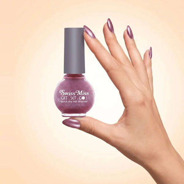 Swiss Miss Get Set Go Quick Dry Nail Enamel in shade Pink Carnation 822 held by hand showing round glass bottle with shimmering metallic mauve carnation pink polish and matching manicured nails.