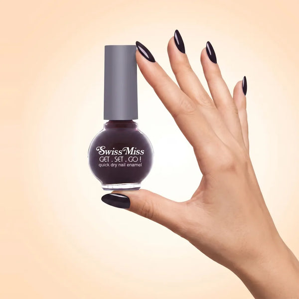Swiss Miss Get Set Go Quick Dry Nail Enamel in shade Satin 214 held by hand showing round glass bottle with deep dark plum black polish and matching manicured nails.