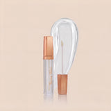 Swiss Miss High Shine Lip Gloss in clear shade 100 Glass Glow featuring rose gold cap, applicator wand, and glossy transparent swatch.