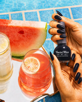 Hand holding Swiss Miss Black 294 Get Set Go quick dry nail enamel bottle displaying glossy jet black polish applied on long nails.