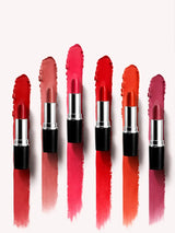 Lineup of open Swiss Miss Classic Lipstick tubes standing over matching long color swatches.