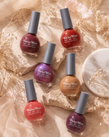 Flat lay arrangement of Swiss Miss Get Set Go quick dry nail enamel bottles on stone slabs with dried florals.