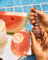 Hand holding Swiss Miss Metallic Brown 249 Get Set Go quick dry nail enamel bottle showing applied metallic brown shade on nails.