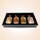 Top-down view of four Swiss Miss mini perfume bottles neatly set inside a black velvet gift box insert.