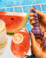 Hand holding Swiss Miss Misty Mauve 507 Get Set Go quick dry nail enamel bottle displaying elegant muted dusty mauve polish applied on long nails.