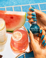 Hand holding Swiss Miss Sapphire Sparkle F-401 Get Set Go quick dry nail enamel bottle displaying sparkling metallic teal blue glitter polish applied on long nails.