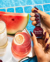 Hand holding Swiss Miss Shocking Pink 285 Get Set Go quick dry nail enamel bottle displaying deep magenta pink polish applied on long nails.