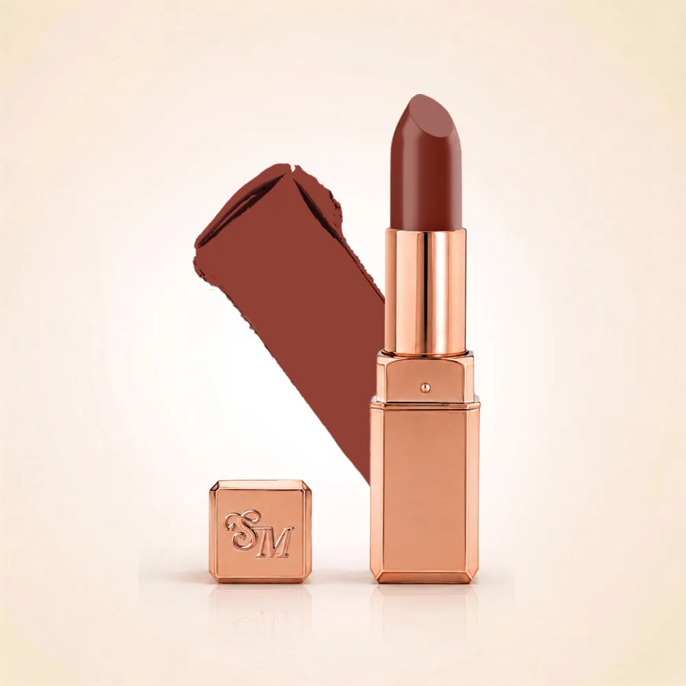 Swiss Miss Silk Lipstick in shade Blushing Babe (733) in gold bullet packaging shown alongside a textured cream color swatch.