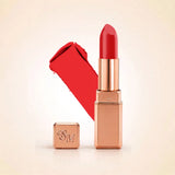 Swiss Miss Silk Lipstick in shade Coral Pink (726) in gold bullet packaging shown alongside a textured cream color swatch.