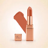 Swiss Miss Silk Lipstick in shade Glitter Bomb (729) in gold bullet packaging shown alongside a textured cream color swatch.