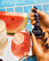 Hand holding Swiss Miss Starlit Night F-403 Get Set Go quick dry nail enamel bottle displaying shimmering deep navy black glitter polish applied on long nails.