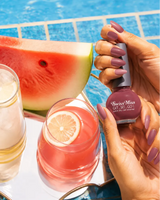 Woman holding Swiss Miss Get Set Go quick dry nail polish in Sugar Pink 209 with matching mauve pink manicure by a pool.