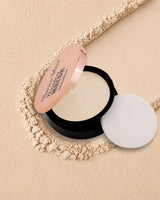 Swiss Miss Flawless Match Compact Powder open case with sponge applicator in shade Light Ivory SM 01 over a textured powder background