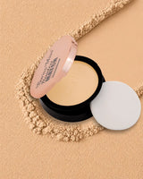 Swiss Miss Flawless Match Compact Powder open case with sponge applicator in shade Natural Beige SM 03 displayed over a textured beige powder background.