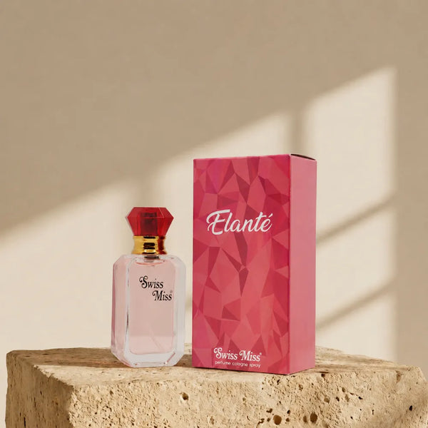 Swiss Miss Elante Perfume 15ml bottle with red diamond cap next to pink geometric box on a stone pedestal