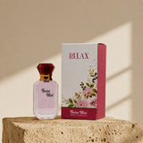 Swiss Miss Relax Perfume 15ml bottle with red cap beside white floral packaging box on a stone pedestal
